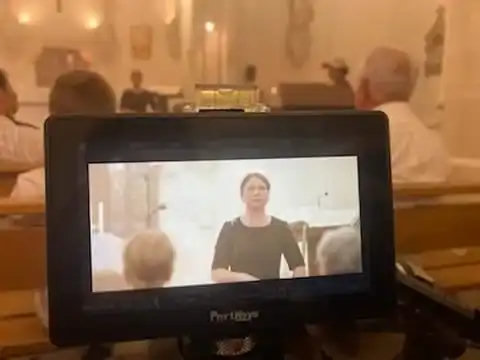 Cérémonie dans une église, avec retransmission vidéo du chant